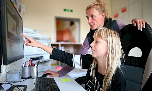 Erzieherin mit einem Mädchen am PC